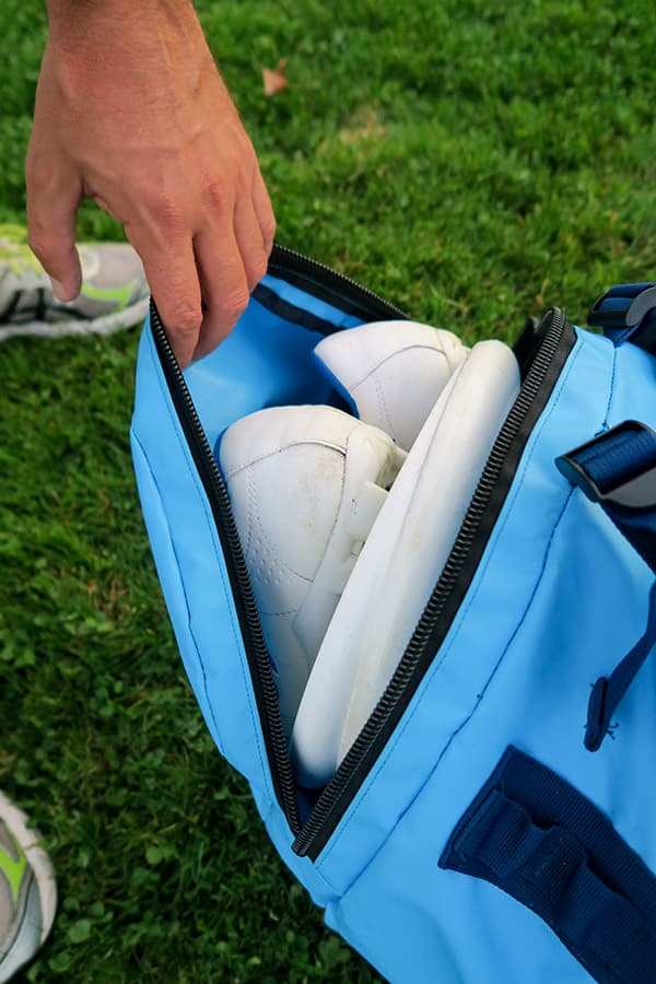 main tenant la poche latérale sur un sac étanche bleu clair