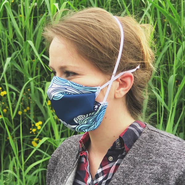 side view of woman wearing a blue waves facemask
