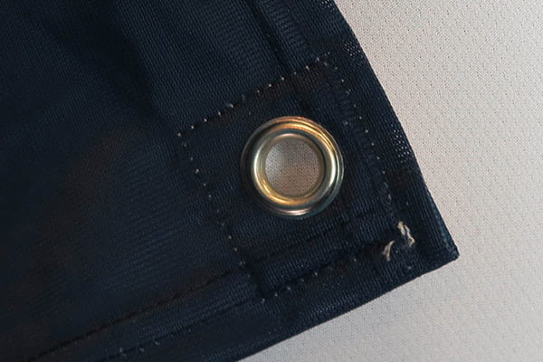 eyelet on dark blue textile with straight stitching