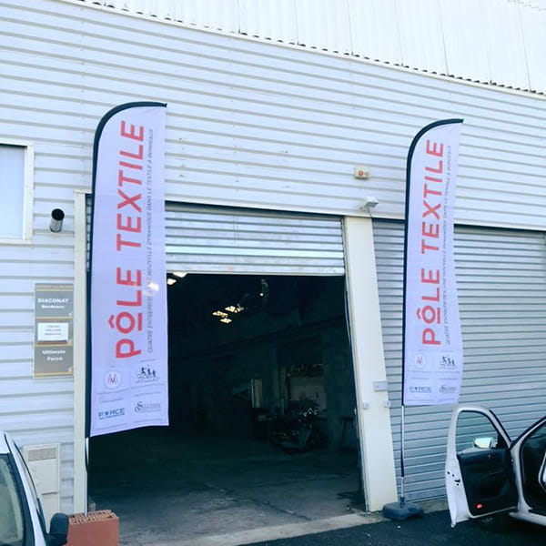 industrial building and two beach flags with pole textile writing