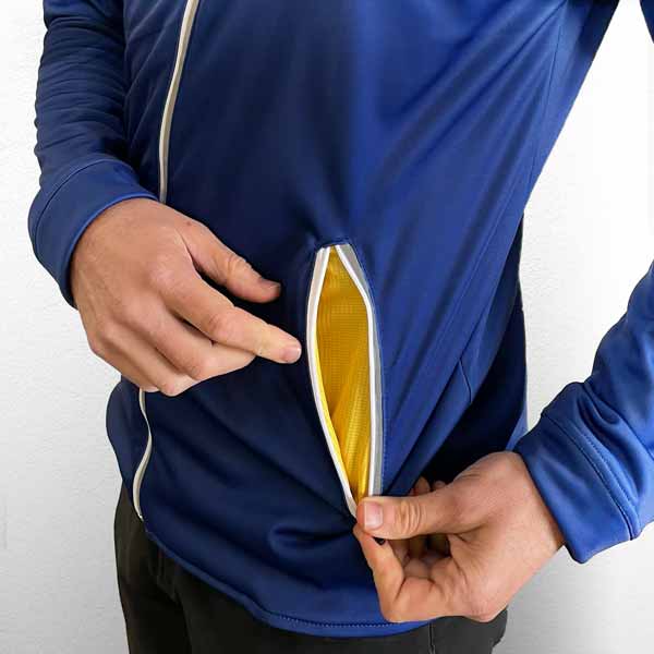 main dans la poche d'une veste de sport noire et bordeaux