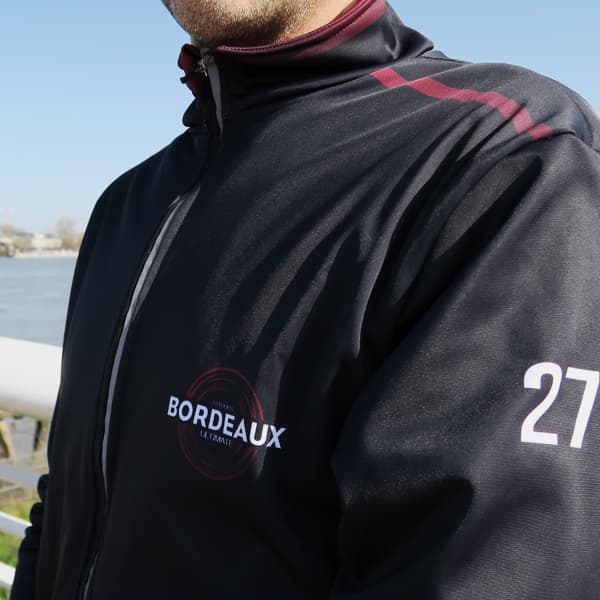vue latérale d'un torse d'homme vêtu d'une veste de sport noire numéro 27