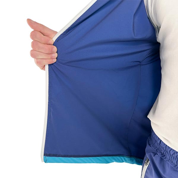 torse d'un homme portant une veste bleue sublimée et tenant la fermeture éclair avec sa main