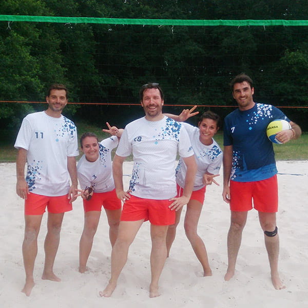 joueurs de volleyball portant des maillots blancs et des shorts rouges