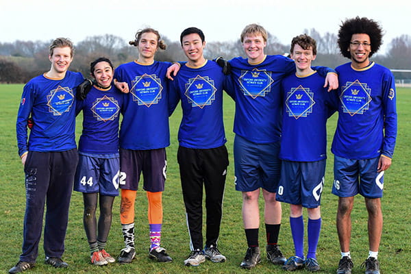 sport team posing on grass field with blue sport outfit