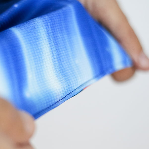 hands stretching a blue sublimated fabric