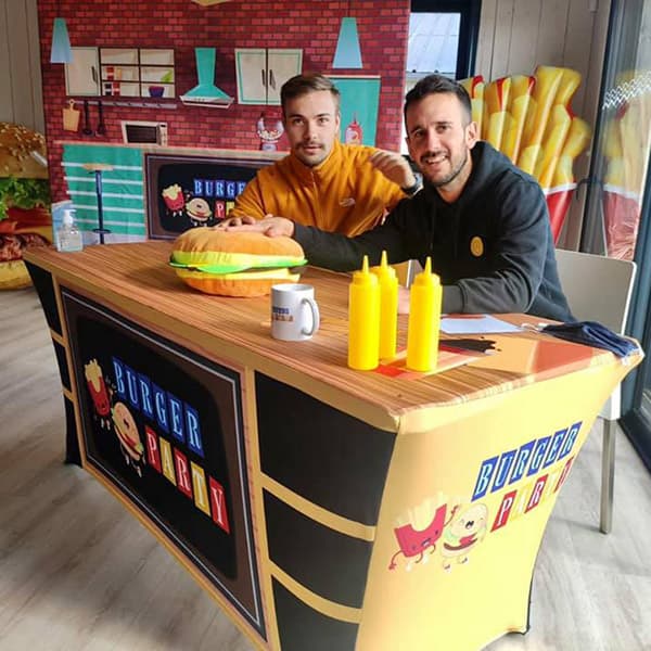 two men at a table in a room recreating a fast food environment