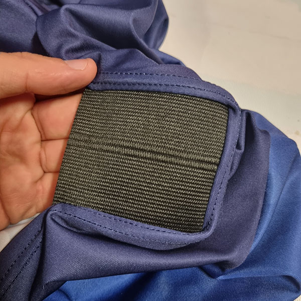 hand holding a blue cloth and reinforced black textile